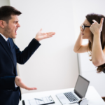 Side View Of Business People Quarreling At Desk In Office