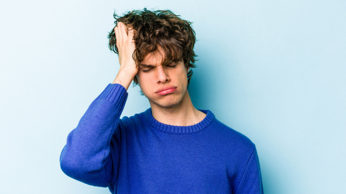 Young caucasian man isolated on blue background tired and very sleepy