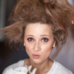 Wedding day. Portrait of a young woman, a bride on the wedding day. Preparation, makeup, do her hair, the hair are crazy, do bouffant comb. The image of orchid flowers.