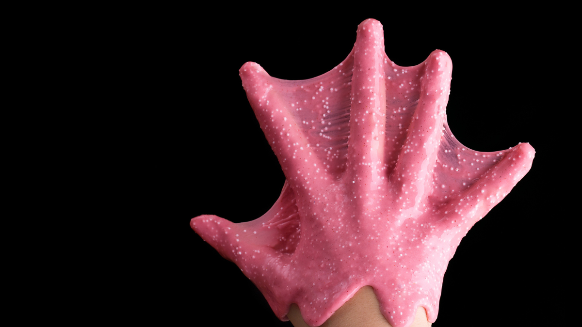 The hand of the child is covered with glue and glitter