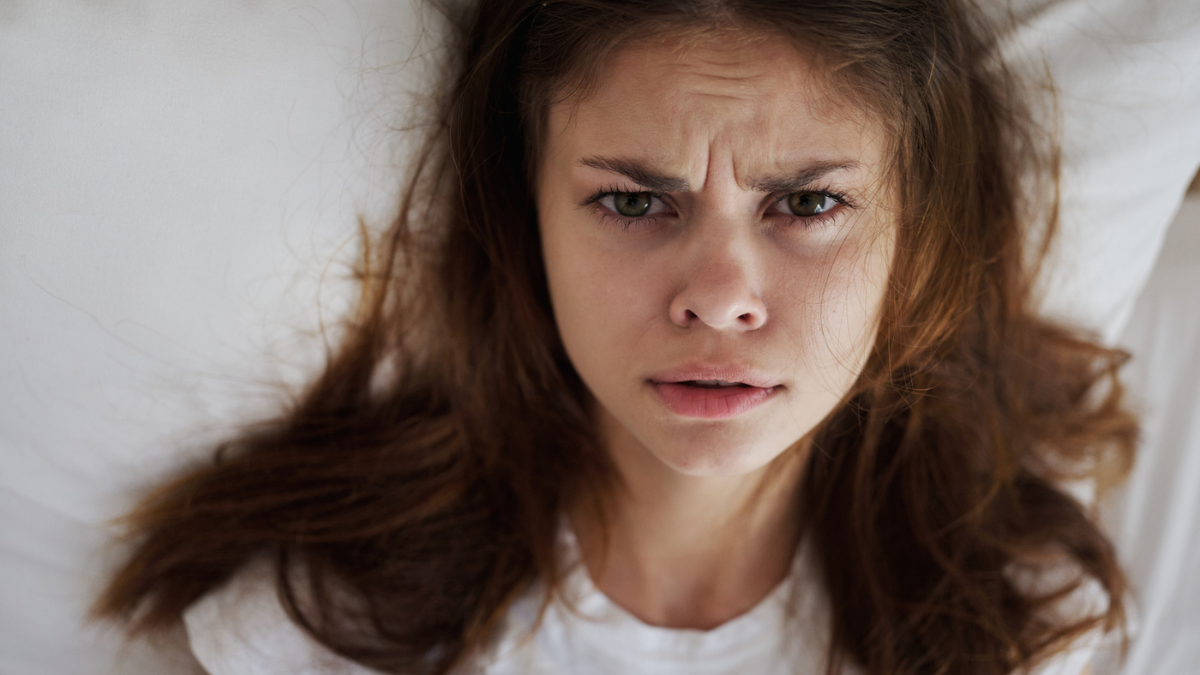 Disappointed woman lying in bed dissatisfaction close-up