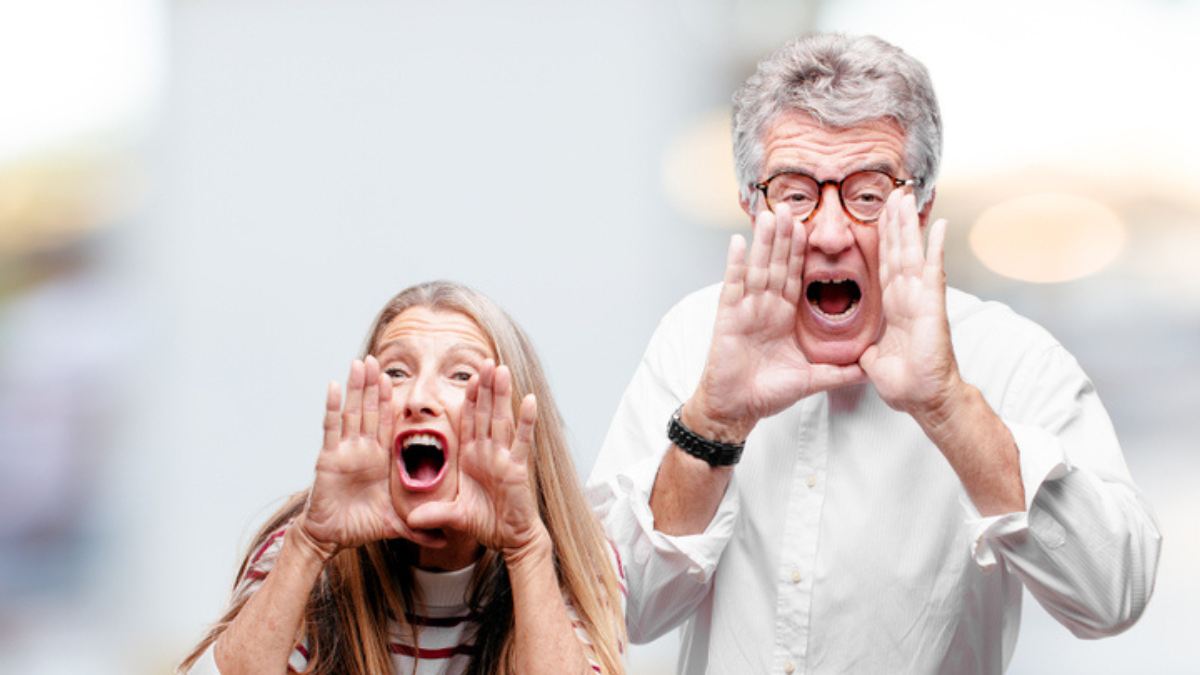 senior cool husband and wife shouting loud like crazy, calling with hand with an angry expression, communicating a big announcement..