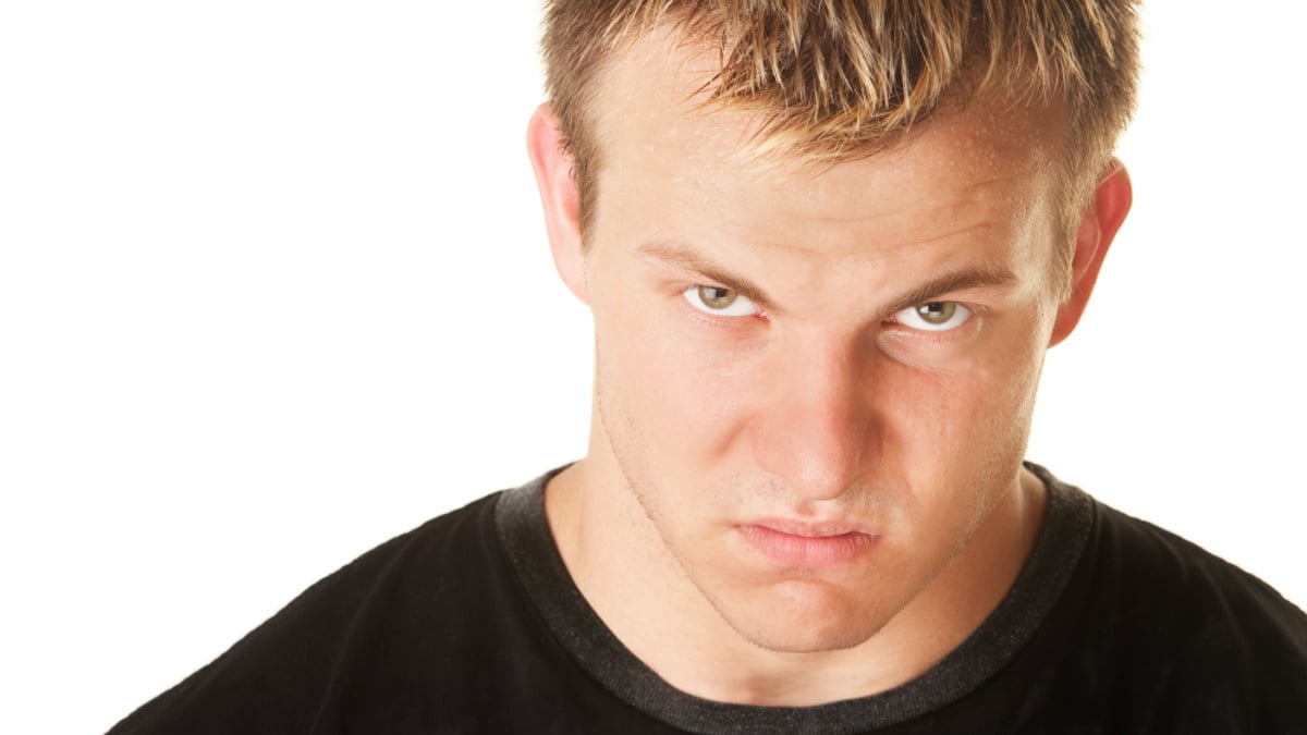 Angry blond muscular European man over white background.