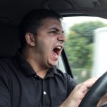 angry man driving a vehicle without seat belt.