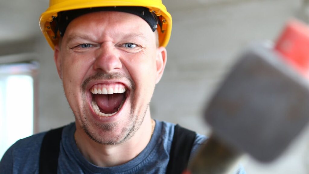 Portrait of screaming male holding big sturdy construction tool.