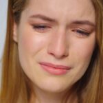 Closeup crying woman posing in studio. Portrait unhappy woman crying on grey background.
