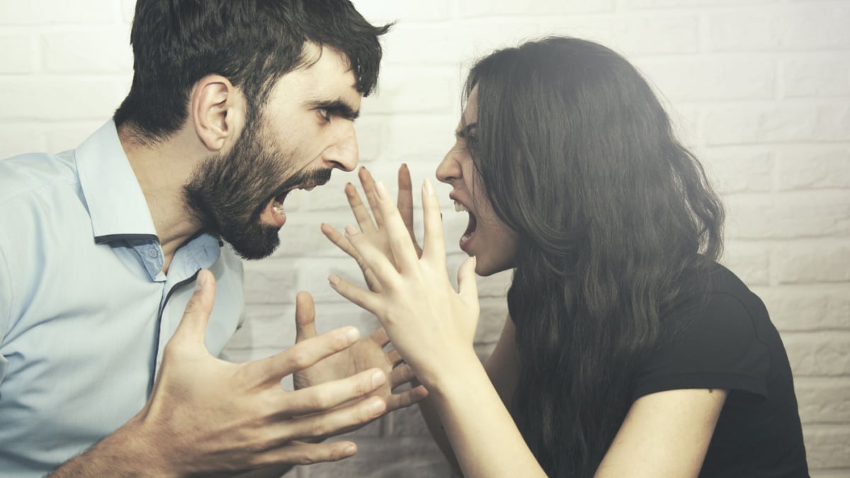 attractive angry couple fighting and shouting at each other.