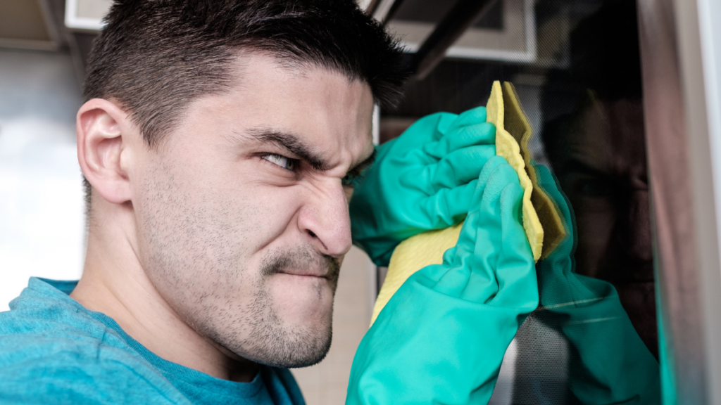 angry Adult man cleaning oven.