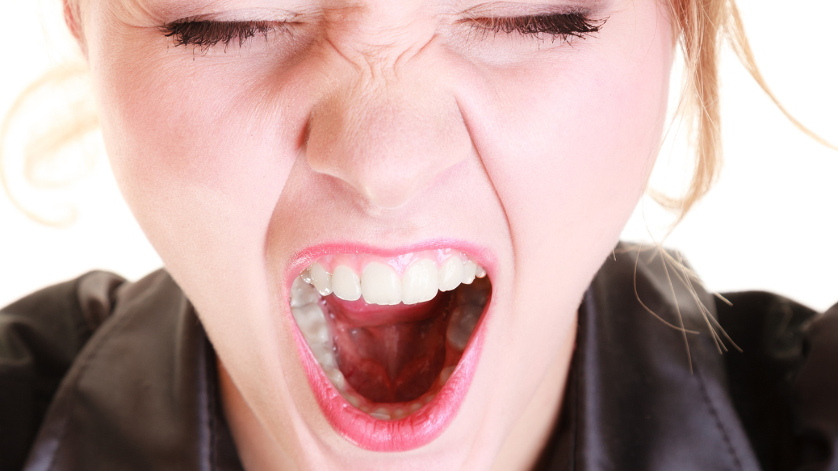 Angry furious woman screaming and pulling messy hair.