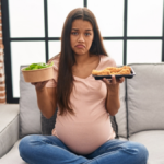 Young pregnant woman craving for food at home depressed and worry for distress, crying angry and afraid. sad expression.