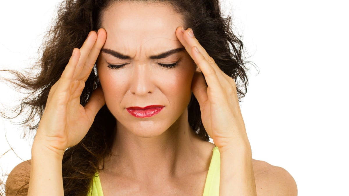 Close-up of a woman with a bad headache or migraine. Isolated on white.