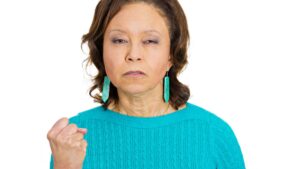 Closeup portrait, angry, cranky, upset, senior mature woman, business worker, clenching her fist, ready to fight isolated white background.