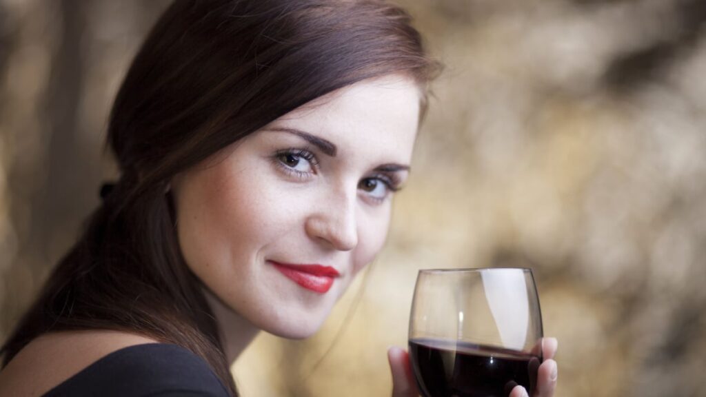 Elegant glamour woman in restaurant with glass of red wine.