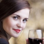 Elegant glamour woman in restaurant with glass of red wine.