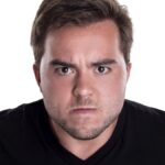 Face of an angry and furious male on a white background. The image is depicting emotions of anger and frustration.