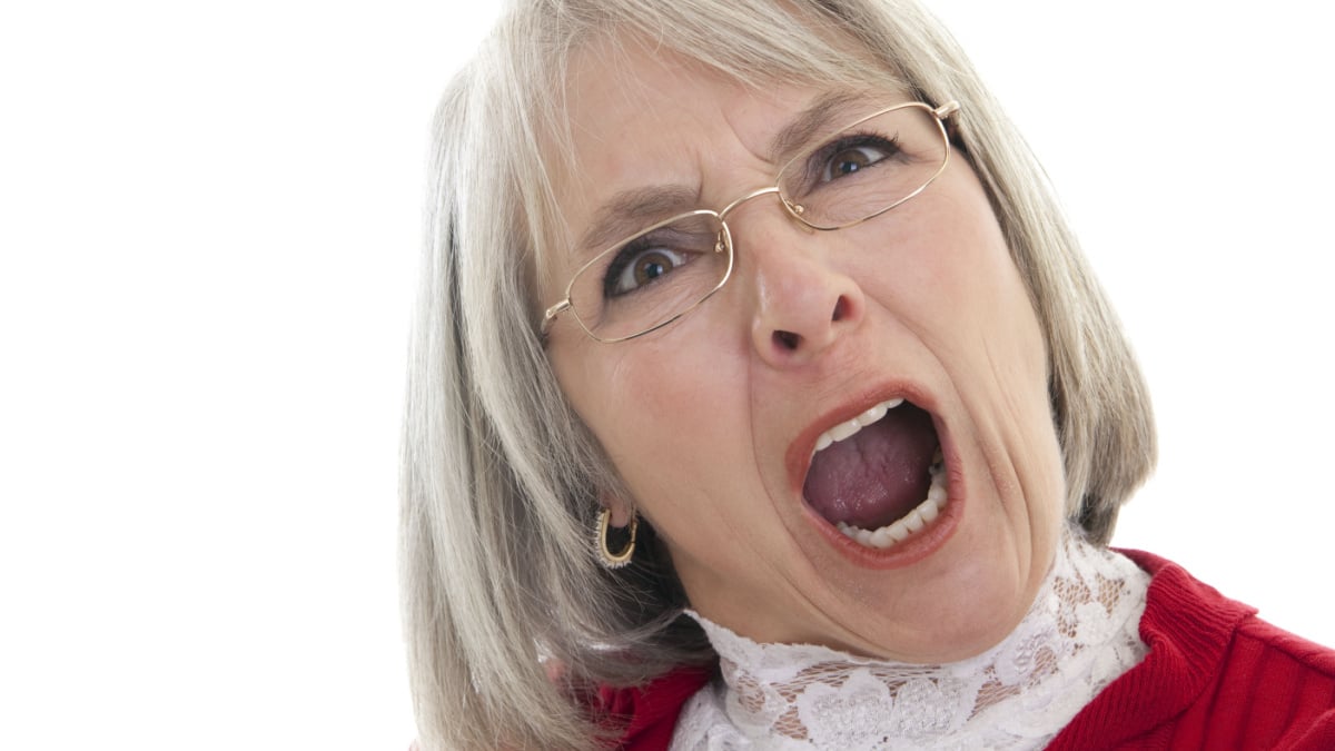 Mature Caucasian woman yelling with an angry expression.