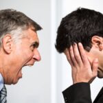 Angry boss shouting to an employee.