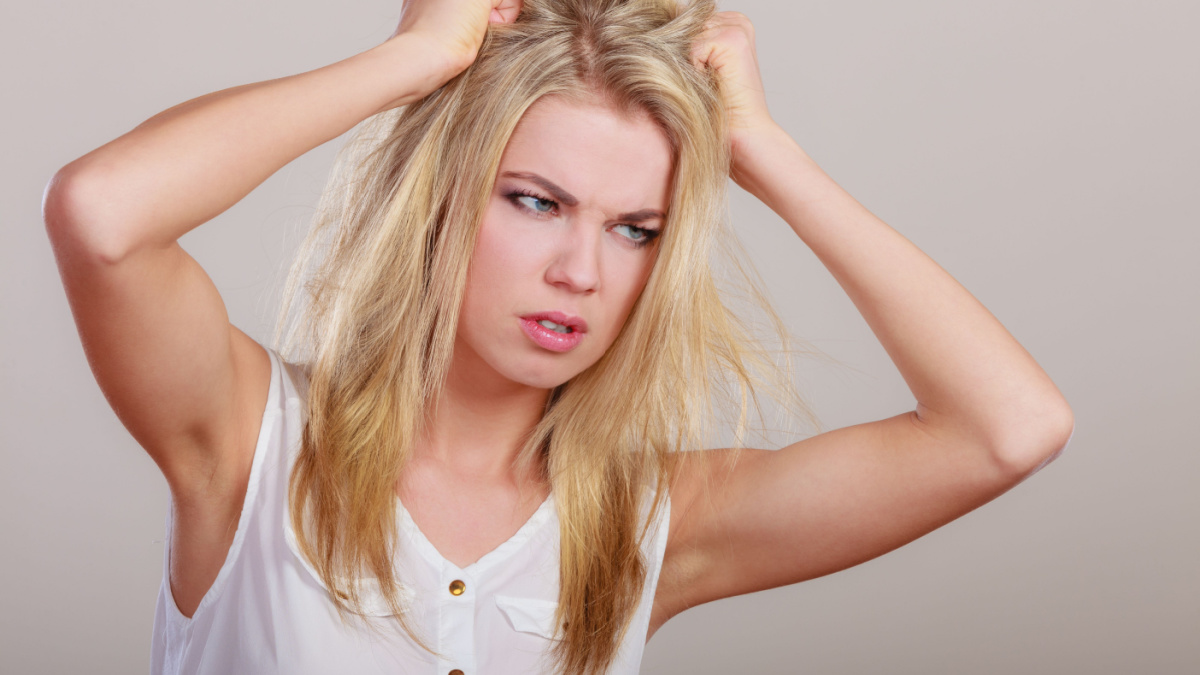 Negative emotions stress. Angry mad woman crazy furious girl pulling messy hair on gray.