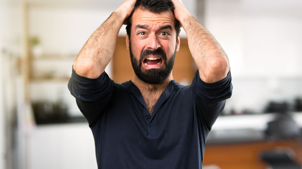 Frustrated handsome man with beard inside house.