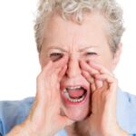 Closeup portrait, mad, angry, upset, hostile, senior mature woman, worker, furious employee, yelling, hands to open mouth, isolated white background.
