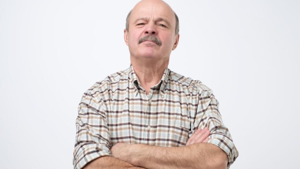 Portrait of selfish senior man crossing hands on his chest..