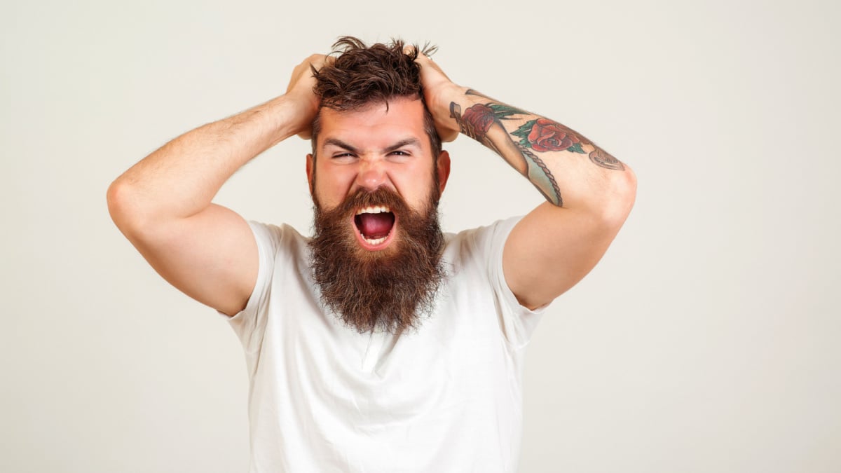 Screaming and angry man. Screaming bearded brutal man over white background.