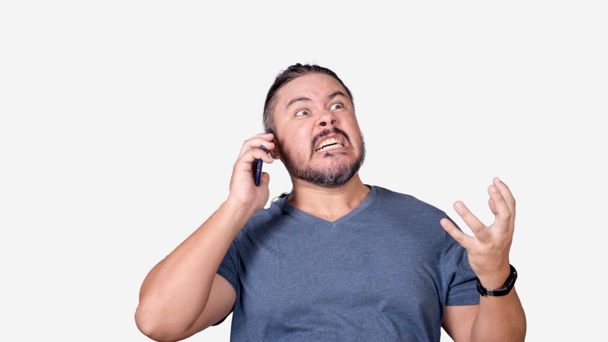 A fuming mad man arguing with a customer service representative over the phone. A livid guy making threats.