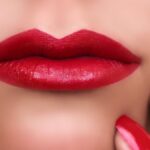 Beautiful sexy woman lips with red lipstick and nail polish. Makeup.