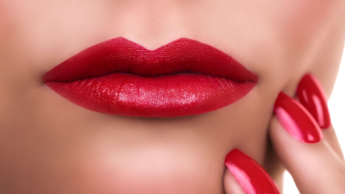 Beautiful sexy woman lips with red lipstick and nail polish. Makeup.