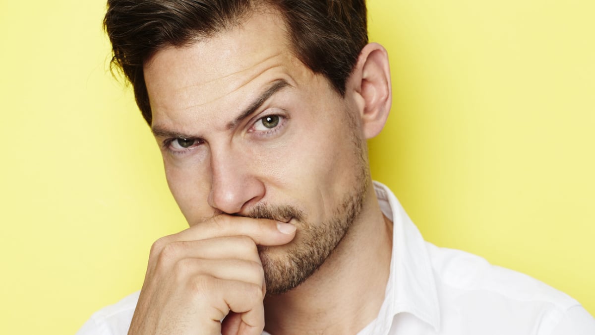 Quizzical man raising eyebrow, portrait.