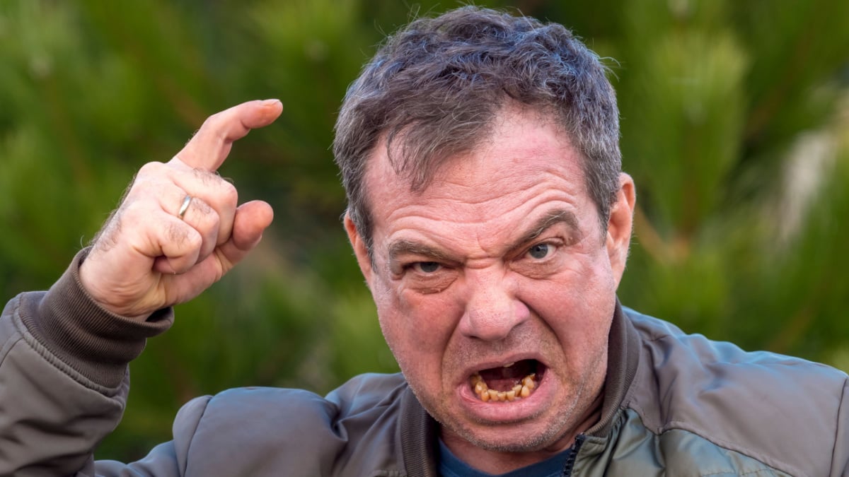 Angry man threatens a finger in nature.