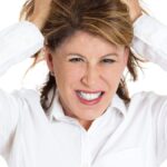 Closeup portrait of young stressed woman pulling her hair out about to have nervous breakdown, isolated on white background.