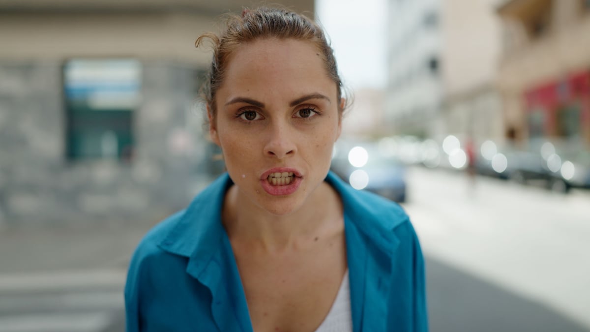 Young woman angry standing at street.