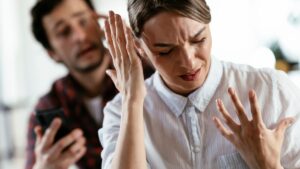 Husband and wife are arguing at home. Angry man is yelling at his wife.