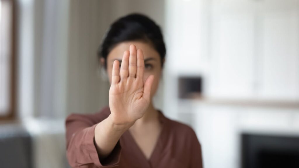 woman holding hand saying no.