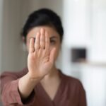 woman holding hand saying no.