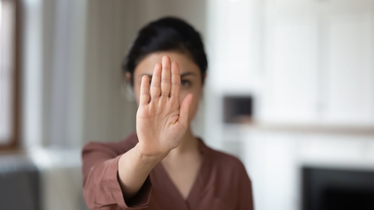 woman holding hand saying no.