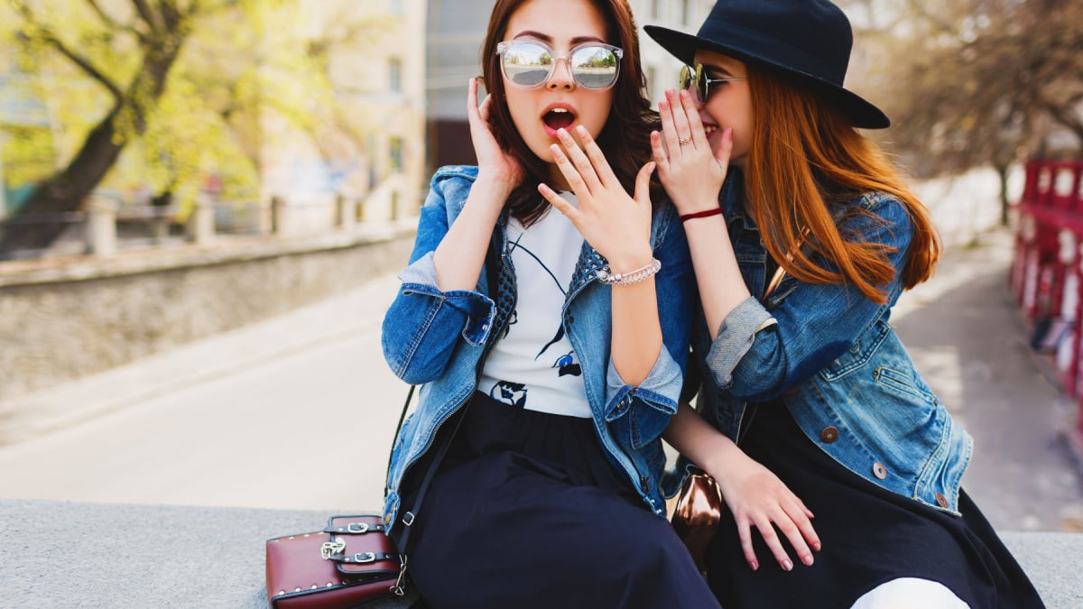 Two pretty cuter teenagers shares secrets, gossip. Surprise face, emotions, Best friends wearing stylish outfit, black hat, sunglasses, dress. Bright spring colors.