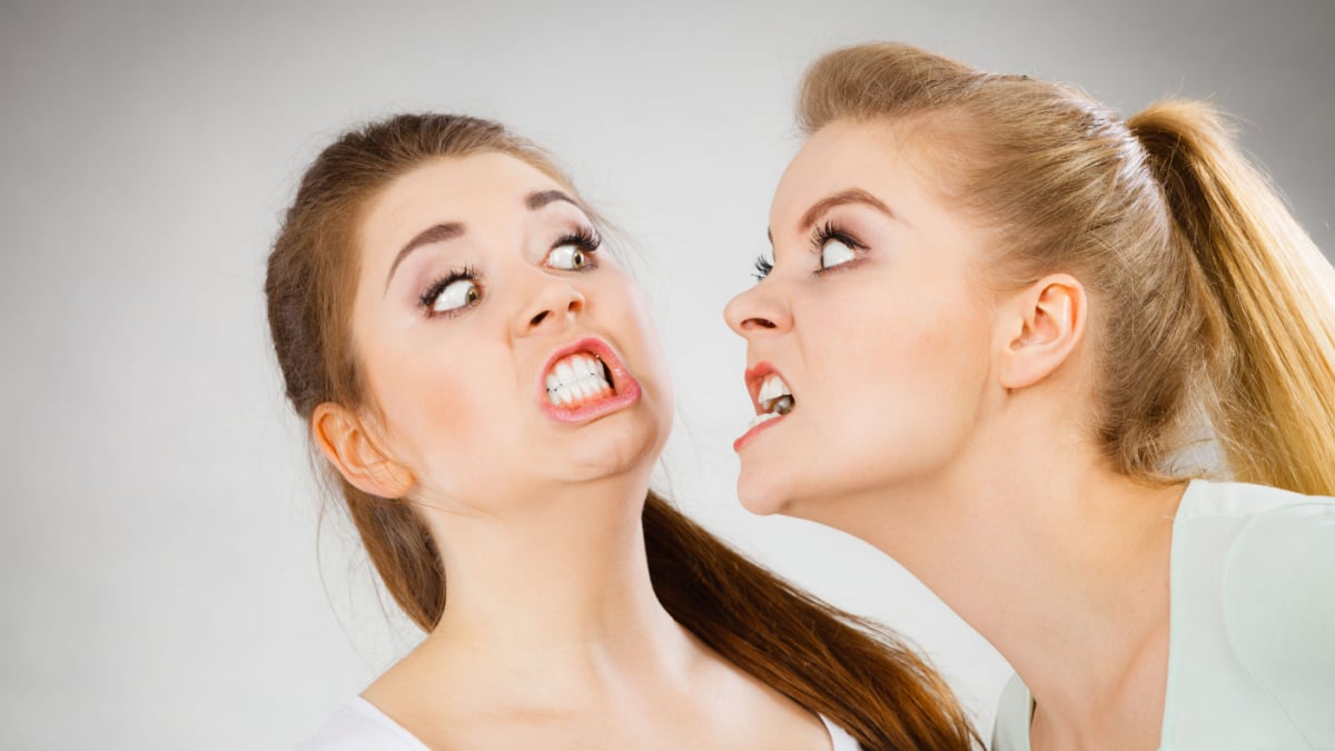 Two agressive women having argue fight being mad at each other.