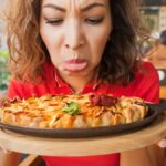 A frustrated woman in a restaurant does not feel the smell and taste of food because of the long covid effect or because of a bad cook.